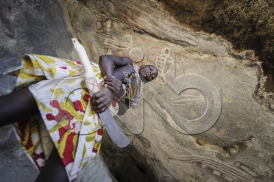 Mucubal/Nyaneka boy guarding old rock paintings at a cave in the Namib Desert